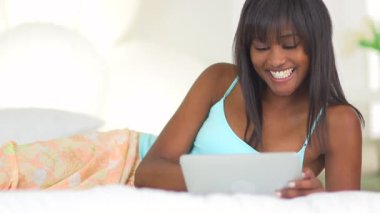 Siyah kadın tabletle oynuyor.