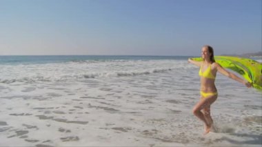 Okyanus kıyısında esintili genç bir kadın.