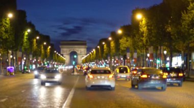 Arka planda Zafer Takı varken geceleri Champs-Elysees 'de kalabalık bir cadde. Paris 'teki ünlü caddenin gece çekimi. Fransa.