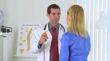 Doktor kadın hastaya ilaç yazıyor.