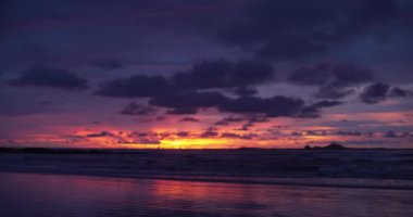 Kosta Rika 'daki plajda turuncu, mor ve mavi günbatımının odak noktası dışında. Yeşil ekran bileşimi için okyanus güneşinin bulanık ya da odaksız görüntüsü. 4k