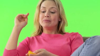 Kanepesinde portakal yiyen bir kadın.