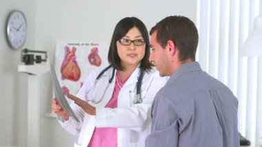 Japon doktor erkek hastaya ilaç yazıyor.