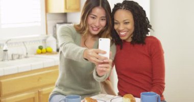 İki kadın kahvaltı yaparken selfie çekiyorlar.