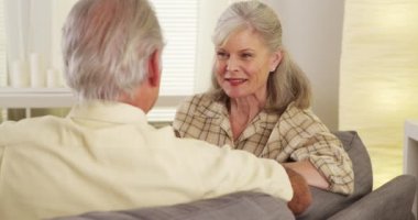 Olgun çift kanepede konuşuyor.