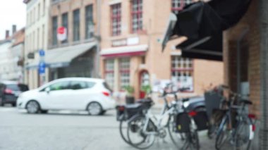 Bruges caddesinin arka planında bisiklet ve mağaza önleri olan bir yer. Yeşil ekran bileşimi için Avrupa şehrinin bulanık video arkaplanı. 4k