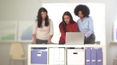 İspanyol iş kadını iş arkadaşlarıyla dizüstü bilgisayarda çalışıyor.