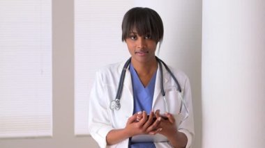 Meşgul zenci kadın doktor gülümsüyor.