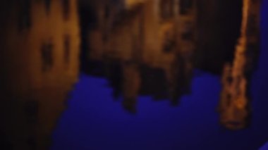 Bruges kanallarında geceleri çatıları yansıtan odak dışı su tabakası. Yeşil ekran bileşimi için dalgalanan sudaki yansımaların bulanık video arkaplanı. 4k