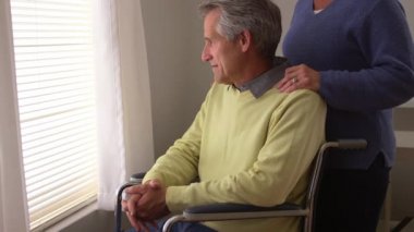 Tekerlekli sandalyede oturan engelli adam