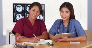 Masa başında oturan Japon ve Meksika tıp doktorları