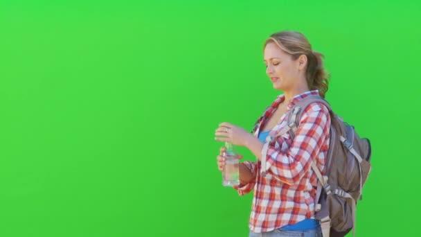 女性ハイカーは左のフレームと水のボトルから飲む — ストック動画