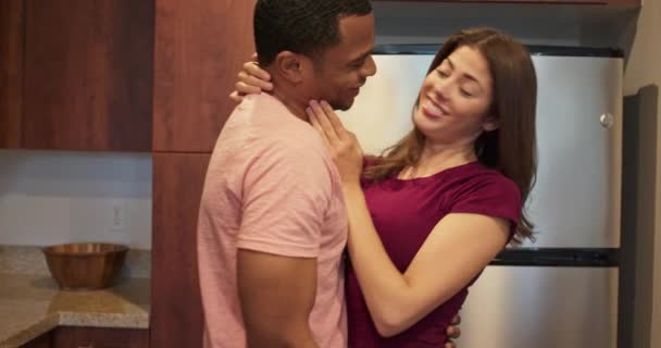 快乐的非洲裔美国人和白人夫妻一起站在厨房里拥抱和欢笑 千禧年男女在家中拥抱 4K慢动作手持 — 图库视频影像