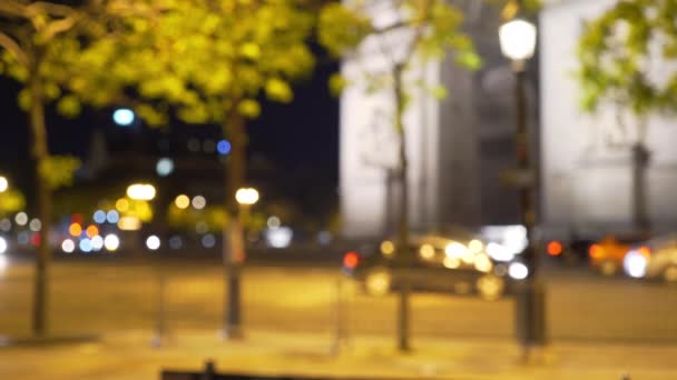 パリの有名な凱旋門を通り過ぎる車の交通量の多い都市のシーン 歴史的なパリの記念碑と夜の活気のある街の通り — ストック動画