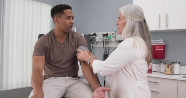 Starší Lékařka Kontroluje Krevní Tlak Mladých Černochů Pomocí Monitoru Stetoskopu — Stock video