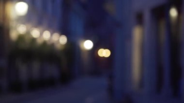 Bokeh 'le Avrupa kaldırım taşı caddesinin bulanık arka plan plakası. Yeşil ekran kompozitasyonu için şehrin arka planında bulanık bir gece görüntüsü. 4k