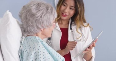 Japon Doktor Olgun kadın hasta ile konuşurken tablet kullanma