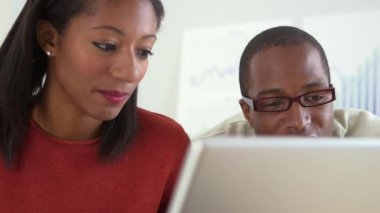 Diz üstü bilgisayar kullanan Afro-Amerikalı işçiler