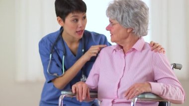 Yaşlı bir hastaya tavsiye veren mutlu Çinli doktor.