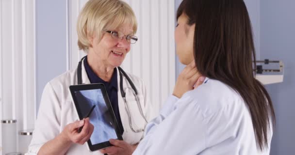 资深医生向年轻中国病人解释颈部X光检查 — 图库视频影像