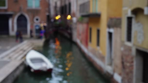 意大利威尼斯一条美丽的狭窄运河的模糊的镜头 灯光反射出水面 傍晚时分 街灯照亮了意大利的运河 — 图库视频影像
