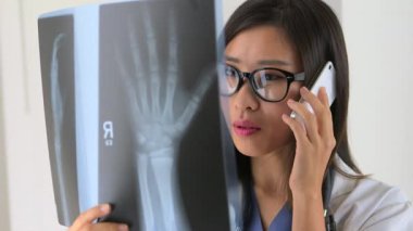 Çinli bir kadın, iPhone 'da partneriyle röntgen hakkında konuşuyor.
