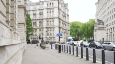 Londra, İngiltere 'deki lüks binaların odaksız görüntüleri. Cazibeli binalarla caddeden geçen arabaların odak noktası dışında. 4k