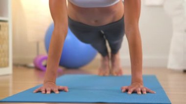 Sağlıklı sarışın kadın şınav çekerken yere yığılıyor ve gülüyor.