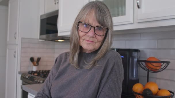 Близький Портрет Старшої Сірої Жінки Окулярами Дивляться Камеру Кухні Старі — стокове відео