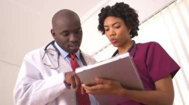 Afro-Amerikalı doktorlar sağlık raporlarını inceliyor.