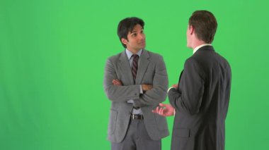 İki işadamı yeşil ekranda dikiliyor ve konuşuyor