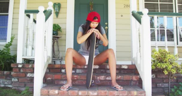 Ισπανόφωνος Γυναίκα Που Κάθεται Στην Βεράντα Skateboard — Αρχείο Βίντεο