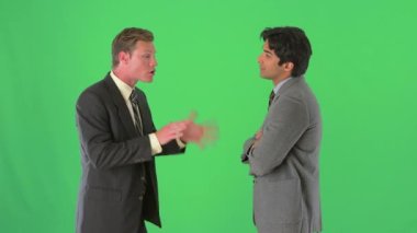 İki işadamı yeşil ekranda dikiliyor ve konuşuyor