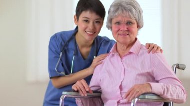 Yaşlı hastası olan mutlu bir Asyalı doktor.