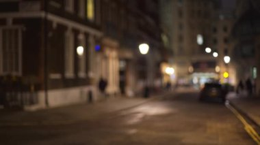 Akşamları karanlık Londra caddesinin bulanık görüntüsü. Geceleri neredeyse boş olan şehir sokağının odaksız görüntüsü. 4k