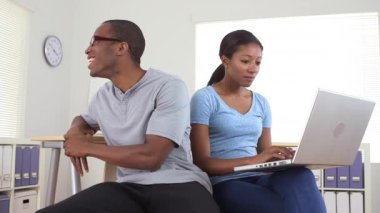 Ofiste dizüstü bilgisayarla çalışan Afro-Amerikalı iş arkadaşları