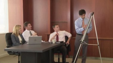 Genç iş adamı iş arkadaşlarına sunum yapıyor.