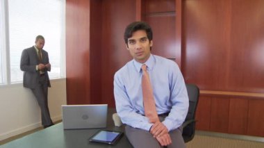 İki işadamı ofiste el sıkışıyor ve konuşuyor.