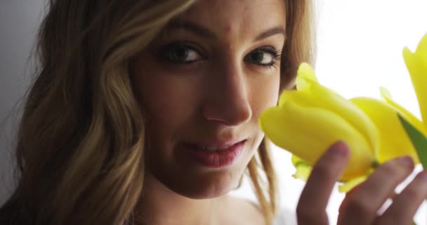 黄色のチューリップの臭いがする幸せな女の子のクローズ アップ — ストック動画