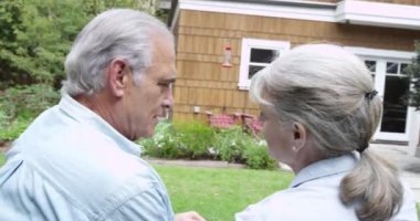 Yaşlı çift bahçede oturmuş konuşuyor.