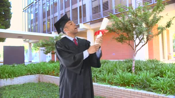 African American Man Graduation Gown Kissing Diploma — Stock Video