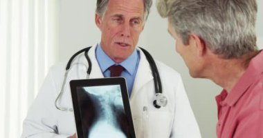 Kıdemli doktor ve yaşlı hasta olumlu bir konuşma yapıyorlar.