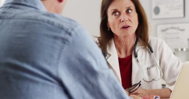 高齢患者と話すデスクに座っているシニア医師 — ストック動画