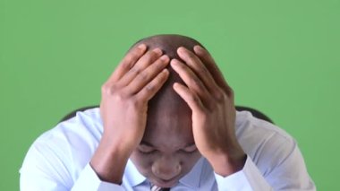 Kafasını ovuşturan üzgün Afrikalı Amerikalı iş adamı