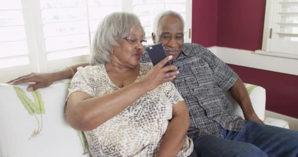 Happy Senior African Couple Sitting Couch Talking Phone — Stock Video