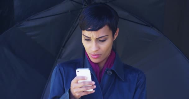 Mujer Negra Con Paraguas Pie Bajo Lluvia Usando Teléfono Móvil — Vídeo de stock