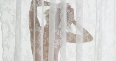 Perdenin arkasında dikilen Afrikalı kadın.