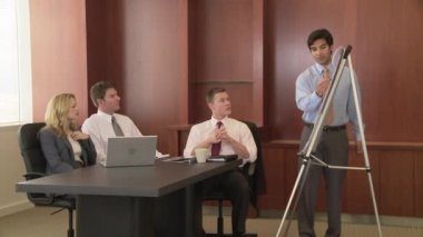 Genç iş adamı iş arkadaşlarına sunum yapıyor.