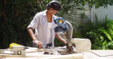 Siyah kadının ev geliştirme ahşap ölçme yapması