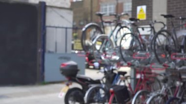Londra arka sokağındaki bisiklet parkının odak noktası dışında. İngiltere 'nin Londra semtindeki bisiklet standının odaklı olmayan manzarası. 4k
